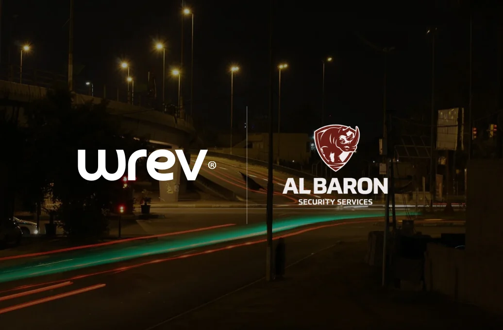 The Wrev and AL Baron Security Services logos over a night-time road with light trails