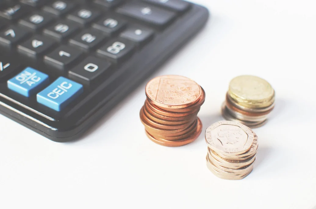 Calculator and coins on a desk